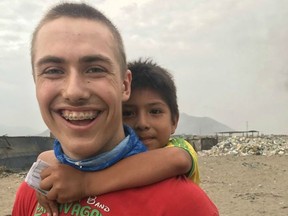 A child from Trujillo, Peru, gets a piggyback from Londoner Benjamin Toth, 16, one of 18 teens from three area churches stranded in the South American nation, which is in lockdown over the coronavirus pandemic. (Supplied/Celeste Toth)