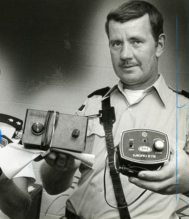 S.Sgt. Dan McDougall holds two types of radar detection devices, that have been confiscated, 1980. (London Free Press files)