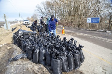 Volunteers fill sand bags for use by residents of Erie Shore Drive in Chatham-Kent, Ont. on Sunday March 1, 2020. The barrier has been erected to prevent farm land from being flooded. Residents of Erie Shore Drive have a deadline of March 9 to vacate their properties so that repairs can be made to the dike on top of which the road sits. Derek Ruttan/The London Free Press/Postmedia Network