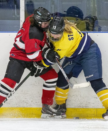 STA Flame Grace Moir (left)  fights for a loose puck in the corner with St. Joe's Ram Jaimie Giles during their TVRA District AA girls hockey game at the St. Thomas Elgin Memorial Centre in St. Thomas, Ont. on Tuesday March 3, 2020.The Flames won the game 4-1 forcing a third and final game in their championship series on Wednesday. Derek Ruttan/The London Free Press/Postmedia Network