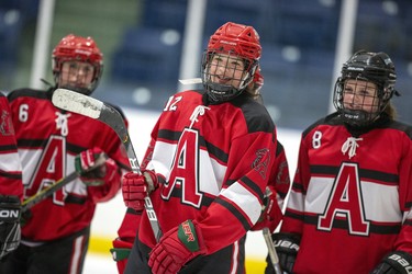 Flanked by Cadence Peroxiding (left) and Grace Moir (rSTA Flame Emma Pais was all smiles after putting her team up 4-0  against the St. Joe's Rams during their TVRA District AA girls hockey game at the St. Thomas Elgin Memorial Centre in St. Thomas, Ont. on Tuesday March 3, 2020.The Flames won the game 4-1 forcing a third and final game in their championship series on Wednesday. Derek Ruttan/The London Free Press/Postmedia Network