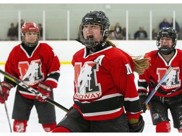 Flanked by Natasha Chisolm, left, and Sarah Kennedy, Katherine Heard screams with delight after scoring against the Lucas Vikings with two minutes left in the game to give her Medway Cowboys a 3-2 lead. The Cowboys protected their lead for the their eighth consecutive TVRA Central AAA girls hockey championship at Stronach Arena  in London on Thursday. (Derek Ruttan/The London Free Press)