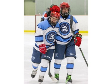 Lucas Vikings captain Alyssa Wouda, right, congratulates Georgia Lambrinos  after she put her team ahead 2-1 in the third period their TRVA Central girls hockey championship game against the Medway Cowboys at Stronach Arena in London on Thursday. (Derek Ruttan/The London Free Press)