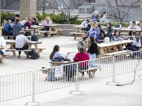 Western University students fill the picnic tables on Concrete Beach during Monday’s mild weather.  Western, along with Fanshawe College, is  keeping close tabs on COVID-19 and is prepared to launch extra infection prevention measures on campus if needed. (DEREK RUTTAN, The London Free Press)