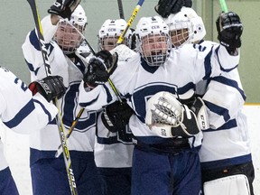 Patterson McNair is swarmed by CCH Crusaders teammates after he scored an empty net goal with ten seconds left to cement a 4-2  win over the Lucas Vikings in the WOSSA AAA championship game at Stronach Arena  in London, Ont. on Tuesday March 10, 2020.  (Derek Ruttan/The London Free Press)