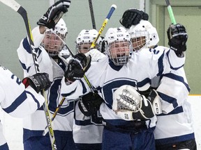 Patterson McNair is swarmed by CCH Crusaders teammates after he scored an empty net goal with 10seconds left to cement a 4-2  win over the Lucas Vikings in the WOSSA AAA championship game at Stronach Arena  in London on Tuesday. (Derek Ruttan/The London Free Press)