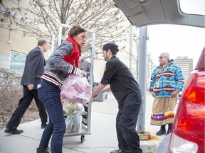 Budweiser Gardens catering manager Sandra Doyle and sous chef Jeff Harding load fresh produce into a van outside the arena on March 13. The venue donated $1,000 worth of produce originally purchased for luxury suites at London Knights games to My Sister’s Place after they were cancelled. A Free Press reader thinks Londoners need more stories about people doing uplifting things during the COVID-19 crisis. (Derek Ruttan/The London Free Press)