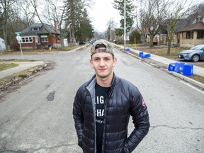 Western University social sciences student Matt Peretz stands in the middle of Broughdale Avenue, a popular student party venue that's eerily quiet amid coronavirus precautions this St. Patrick's Day. Peretz, who shares a house on Broughdale, is heading home to Vancouver Wednesday. (Derek Ruttan/The London Free Press)