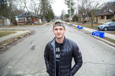 Western University social sciences student Matt Peretz stands in the middle of Broughdale Avenue, a popular student party venue that's eerily quiet amid coronavirus precautions this St. Patrick's Day. Peretz, who shares a house on Broughdale, is heading home to Vancouver Wednesday. (Derek Ruttan/The London Free Press)