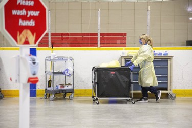 A health care worker transports supplies inside Oakridge Arena which has been transformed into a coronavirus assessment centre in London, Ont. on Tuesday March 17, 2020.  Derek Ruttan/The London Free Press/Postmedia Network