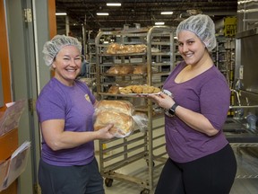 Michelle Crook (left), owner of Bosco and Roxy's, and sales manager Samantha Clark hold a sampling of some of the baked goods they are now producing in London. Normally the company makes dog treats. The COVID-19 crisis has them baking human food now instead. Crook says they hope to produce 3,000 to 4,000 loaves of bread a day. (Derek Ruttan/The London Free Press)