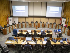 Councillors Michael van Holst (standing), Maureen Cassidy and Paul Van Meerbergen were seated at desks normally reserved for city staff to allow safe distancing of councillors around the horsehoe during a council meeting at city hall in London on Tuesday March 24, 2020. Five members of council, Anna Hopkins, Steve Hillier, Josh Morgan, Steve Lehman and Mayor Ed Holder participated through video conference. (Derek Ruttan/The London Free Press)