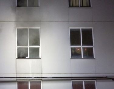 Smoke pours out of a 4th floor apartment window while a firefighter can be seen in the window beside it. Firefighters were dispatched to 446 King Street in London, Ont. on Friday March 27, 2020 around 8:00pm. One person was taken to the hospital with unknown injuries.   Derek Ruttan/The London Free Press/Postmedia Network