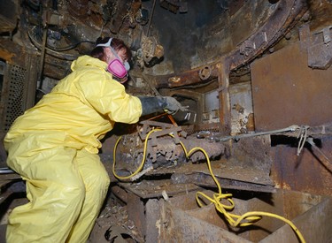 Valerie Dawes of the property damage firm Winmar cleans out the inside of the Holy Roller tank in Victoria Park on Tuesday August 15, 2017. (Free Press files)