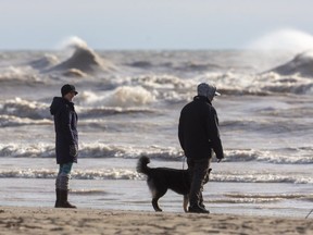 Jenny Lang and Zach Vandenbroek of Port Stanley, out dog-walking, enjoy the views of breaking waves on Lake Erie at Port Stanley's main beach, one of many places in Southwestern Ontario where visitors can admire the majesty of the Great Lakes. (MIKE HENSEN, The London Free Press)