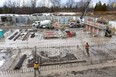 Mark Matschke and Matt Cotnam work on some rebar at the latest Tricar construction site north of Sunningdale Road just east of Sunninghill Golf and Country Club in London, Ont.  Four towers are planned for the location ( Mike Hensen/The London Free Press)