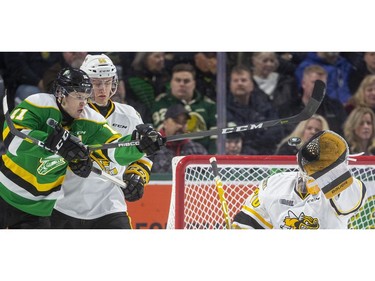 Knights forward Connor McMichael lunges to try to deflect a high shot past Sting goalie Benjamin Gaudreau while being checked by Eric Hjorth during the first period of their OHL game  Friday March 6, 2020, at Budweiser Gardens. Mike Hensen/The London Free Press