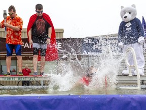 Peter Mertens, a Special Olympics athlete, was the first to hit the frigid water Tuesday March 10, 2020 for the St. Thomas Police fundraiser in St. Thomas. His partners in the polar plunge, Shane Northey, left, and Andy Smiari, wait for their turn to raise funds for Special Olympics. (Mike Hensen/The London Free Press)