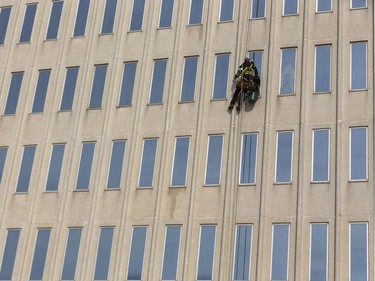 Jamie Conyers washing windows downtown in London, Ont. shouldn't have too much trouble keeping at least 6 feet away from people on his job. Photograph taken on Monday March 16, 2020.  Mike Hensen/The London Free Press/Postmedia Network