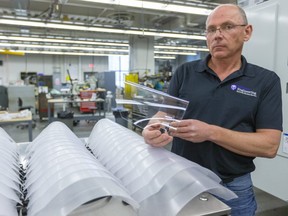 Clayton Cook, the manager of Western's University Machine Services on campus shows off the final version of their shields they are making out of sheets of polycarbonate (PETG) that can be used by front line medical workers to protect themselves with other PPE from Covid-19.  The polycarbonate comes from the manufacturer with plastic wrap which will only be removed when the mask is about to be used. (Mike Hensen/The London Free Press)