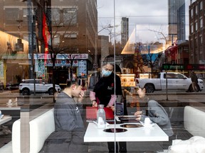 A server attends to customers at a restaurant in the Chinatown district of Toronto in late January. Asian restaurants in Canada have already seen a drop in sales.