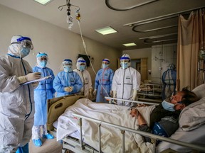 Medical staff speak with a patient infected by the COVID-19 coronavirus at Red Cross Hospital in Wuhan in China's central Hubei province on March 10, 2020.