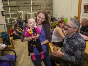 On Tuesday afternoons Anderson Craft Ales hosts a mom and baby drop in program. Here Christina Clayton and 8 month old daughter Allison smile for the camera while Allison's grandfather Marshall Johnston enjoys a glass of beer. (Derek Ruttan/The London Free Press)