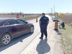 First Nations staff screen cars going across the bridge onto Walpole Island on April 2. Walpole Island restricted almost all non-resident travel to the community on April 1 in an effort to slow the spread of COVID-19. (Jake Romphf, Postmedia Network)