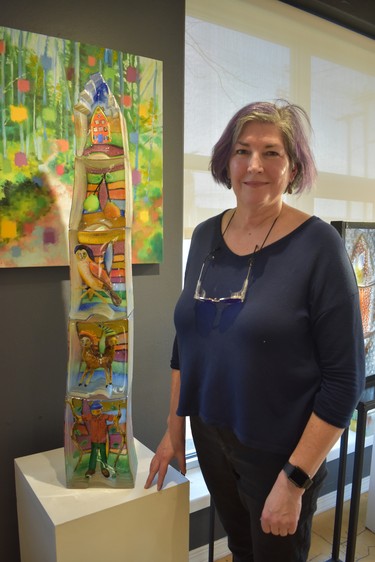 Stephanie Trenchard, known nationally in the U.S. for her glass art, poses by a commissioned piece that chronicles a family story. The towering piece is five separate works stacked together. WAYNE NEWTON/SPECIAL TO LONDON FREE PRESS/POSTMEDIA