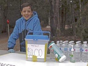 Kallan McMullen, 10, of London looks after his water stand at the end of his aunt Debbie's driveway in Corbeil. The boy, living in the north during the pandemic, raised $500 for the North Bay Food Bank. (Michael Lee/Postmedia News)