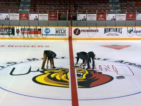 Several people work on the Owen Sound Attack logo at centre ice of the Harry Lumley Bayshore Arena in this Postmedia Network file photo.