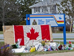 A woman comforts her daughter after they placed flowers at an impromptu memorial in front of the RCMP detachment April 20, 2020 in Enfield, Nova Scotia, Canada. (Photo by Tim Krochak/Getty Images)