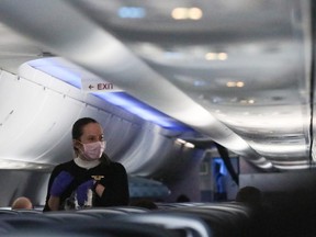 A flight attendant serves a snack on a Baltimore, Maryland bound Delta flight to Hartsfield-Jackson Atlanta International Airport on April 20, 2020 in Linthicum Heights, Maryland. The airline industry has been hit hard by the COVID-19 pandemic, forcing the cancellation and consolidation of flights across the globe. (Photo by Rob Carr/Getty Images)