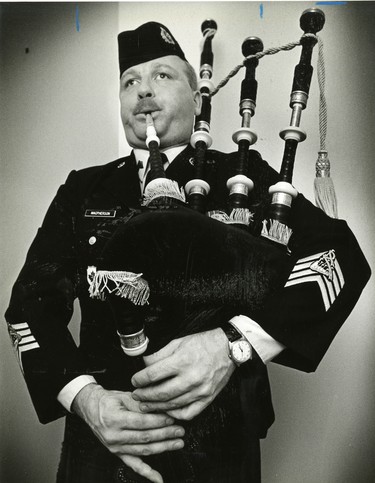 Pipe-Maj. Hugh Macpherson squeezes out a tun during a visit to his parents, 1981. (London Free Press files)