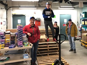 Broadcaster Jamie Campbell (second from left, standing on palettes) pitches in earlier this month at Timmins and District Hospital in the northern Ontario city, where Campbell delivered personal protective equipment from Toronto as part of the COVID-19 medical relief effort.