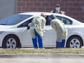 Health care workers assess a person at the Carling Heights Optimist Community Centre COVID-19 assessment centre  in London. Derek Ruttan/The London Free Press/Postmedia Network