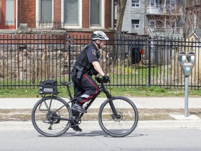 A London police officer cycles along Dundas Street in London. (Free Press file photo)