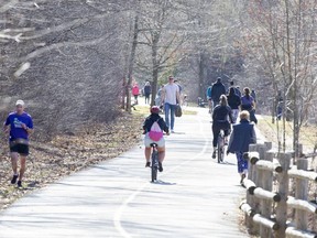 People keep their distance while walking, running and biking beside the Thames River at near Springbank Park in London. (Derek Ruttan/The London Free Press)