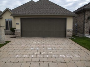 "April distance brings May existence," a timely new take on an old expression was written in chalk on a driveway in north London, Ont. on Tuesday, April 7, 2020. (Derek Ruttan/The London Free Press)