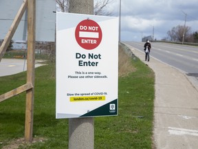 One-way sidewalk signs have been posted at the bridge on Highbury Avenue at Dundas Street  in London. Photo taken on Tuesday April 14, 2020. The sidewalks are too narrow for pedestrians to pass each other while maintaining a six metre distance. Derek Ruttan/The London Free Press/Postmedia Network