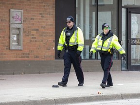 Police constables walk east Dundas Street just past Lyle Street in London, Ont. on Tuesday April 14, 2020. (Derek Ruttan/The London Free Press)