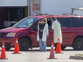 Health care workers assess a person at the Carling Heights Optimist Community Centre COVID-19 assessment centre in London, Ont. on Monday April 20, 2020. (Derek Ruttan/The London Free Press)