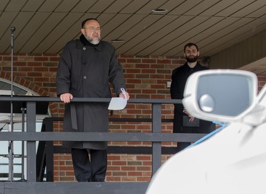 Church of God Pastor Henry Hildebrandt delivers a sermon from a stage in the church's parking lot in Aylmer, Ontario on Sunday April 26, 2020. In defiance of an order by the town's chief of police, the church held a drive-in service Sunday morning. Hundreds of parishioners sat in parked vehicles watching Hildebrandt on stage and listening to his sermon over their FM radios. Police video taped the event but have not yet laid charges. Derek Ruttan/The London Free Press/Postmedia Network