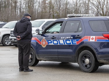 Police speak to Church of God official Herbert Hildebrandt in Aylmer, Ontario on Sunday April 26, 2020. In defiance of an order by the town's chief of police, the church held a drive-in service Sunday morning. Hundreds of parishioners sat in parked vehicles watching Hildebrandt on stage and listening to his sermon over their FM radios. Police video taped the event but have not yet laid charges. Derek Ruttan/The London Free Press/Postmedia Network
