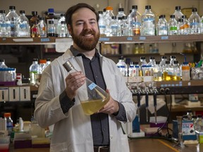Western University PhD candidate Sam Slattery holds a flask in which algae is being grown in London, Ont. on Wednesday April 29, 2020. The algae produces a viral spike protein used to test for COVID-19 antibodies. Derek Ruttan/The London Free Press/Postmedia Network