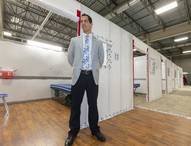 Ian Ball, a critical care doctor for London Health Sciences Centre, stands next to one of the rooms at the LHSC field hospital being constructed at the Western Fair District Agriplex in London on Tuesday. The 144-bed unit will treat patients who are on the mend from COVID-19 but not well enough to go home, said Ball. The unit can expand to 500 beds if the need arises. (Mike Hensen/The London Free Press)