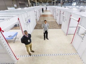 Derek Lall of LHSC and Dr. Ian Ball, a critical care doctor, show off  the COVID-19 field hospital created at the Western Fair's Agriplex this spring. Although it has yet to be used, rising cases means it is being kept at the ready. (Mike Hensen/The London Free Press)