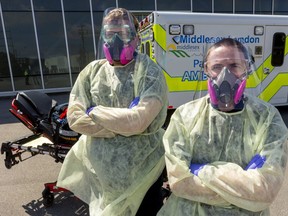 Josh Allen and Damian Gons, from Middlesex-London Paramedic Service, wear their COVID-19 gear in London, Ont., on Wednesday, April 8, 2020. (Mike Hensen/The London Free Press)