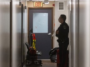 A London police constable guards an eighth-floor unit at 580 Dundas St. Wednesday, April 15, as investigators probe a deadly shooting in the building one day prior. (Mike Hensen/The London Free Press)