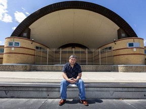 Alfredo Cajax sits in front of a locked up Victoria Park bandshell, site of many SunFest concerts, that will remain shuttered this year due to the COVID-19 pandemic. (Mike Hensen/The London Free Press)